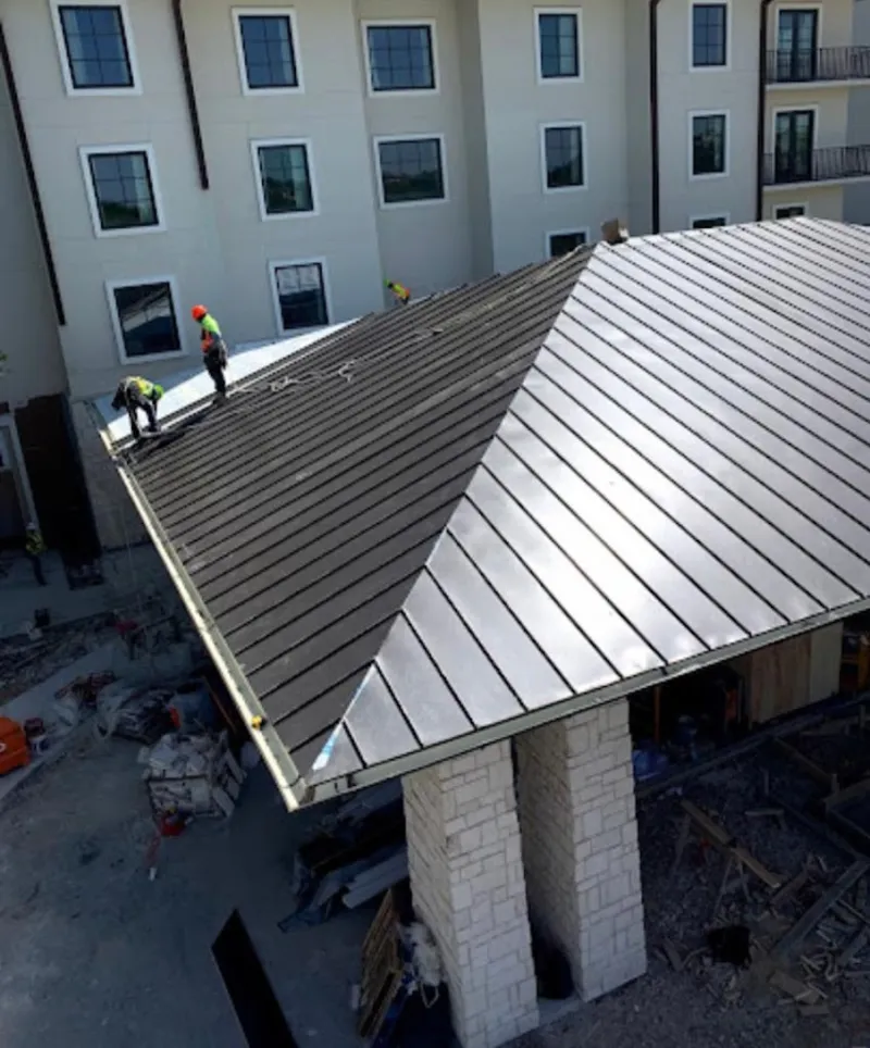 Crew installing standing seam metal roof panels on a commercial project in Damascus